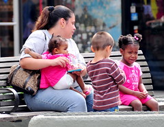 woman with three children on park bench