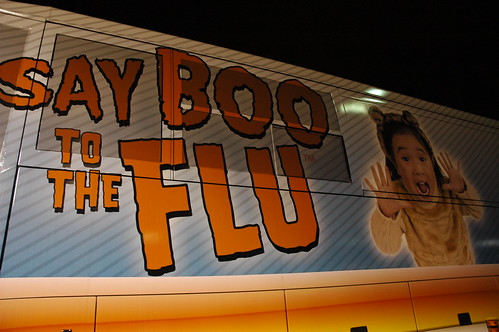 Say BOO to the FLU, sign on the side of a bus, little girl in costume, San Francisco, California, USA by Wonderlane