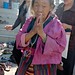 Elder Tibetan Woman, Bodhisattva Day, with her hands in prayer mudra, wearing traditional apron and wrap, malas, two Buddhist women, Tharlam Monastery, Boudha, Kathmandu, Nepal