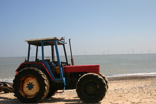The tractor, the fishing  boat and the wind farm. A Norfolk beach.