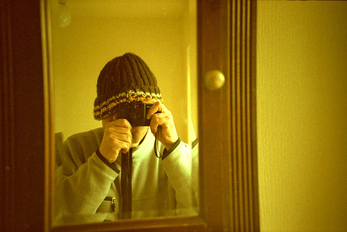 reflected self-portrait with Lomo LC-A+ camera and wooly hat by pho-Tony
