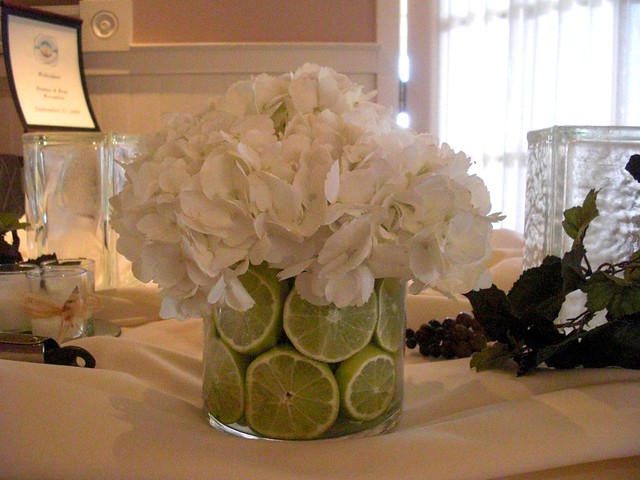 A wedding centerpiece with white hydrangea and green limes
