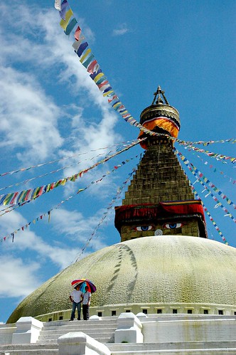 Boudha Stupa, with two friends under an multi-colored umbrella, Tibetan Buddhist prayer flags, Boudha, Kathmandu, Nepal by Wonderlane