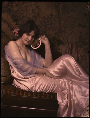Woman in satin dress holding mirror