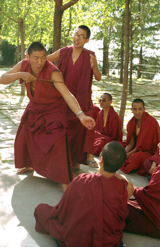 Maroon robed Tibetan Buddhist monks practicing debate, using the mala to illustrate a good point, coaching, argument, at His Holiness the 14th Dalai Lama's monastery in Dharamasala, India, on pilgrimage in 1992 by Wonderlane