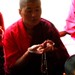 Tibetan nuns recite the mandala offering mudra with crystal mala (rosary)