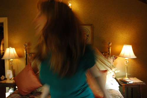 Jessie playing around with her hair as she falls on the bed, between the lamps and silk pillows, Mill Rose Inn, Half Moon Bay, California, USA by Wonderlane