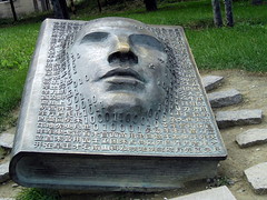 Chinese bronze sculpture, face emerging from book