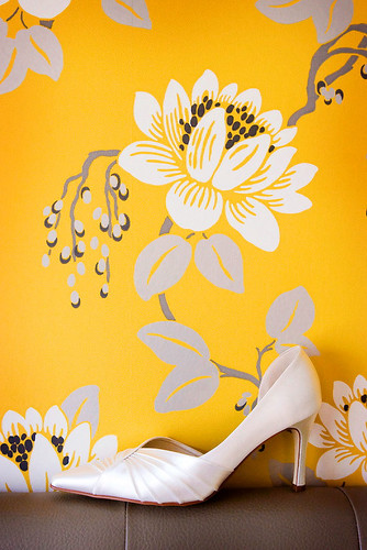 Wedding Photos bridal shoe perched on sofa against a floral wallpaper