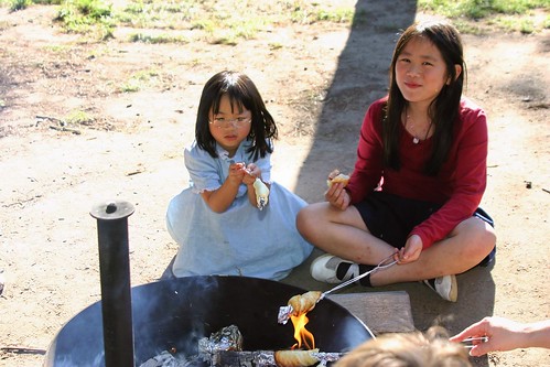 The Girls Making Cinnamon Rolls Over the Campfire