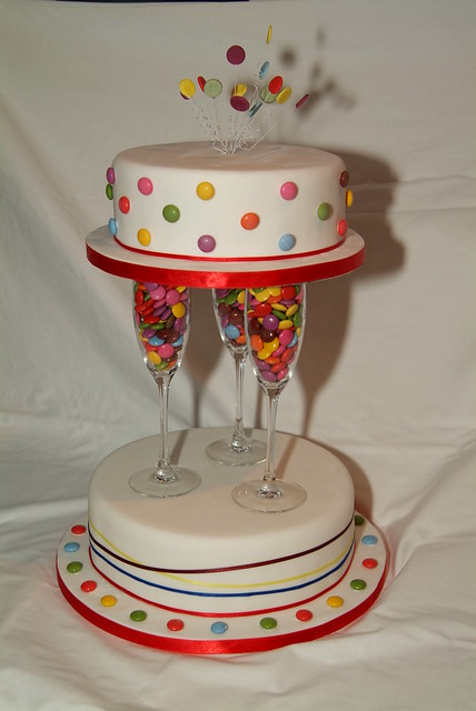 2 Tier Wedding cake second tier held up with champagne glasses filled with
