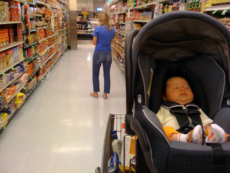 Mom grocery shopping with baby