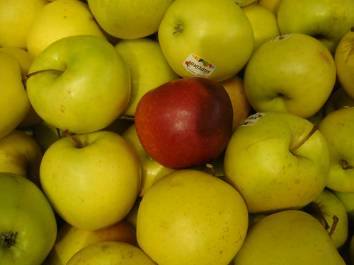 yellow apples with read one in middle