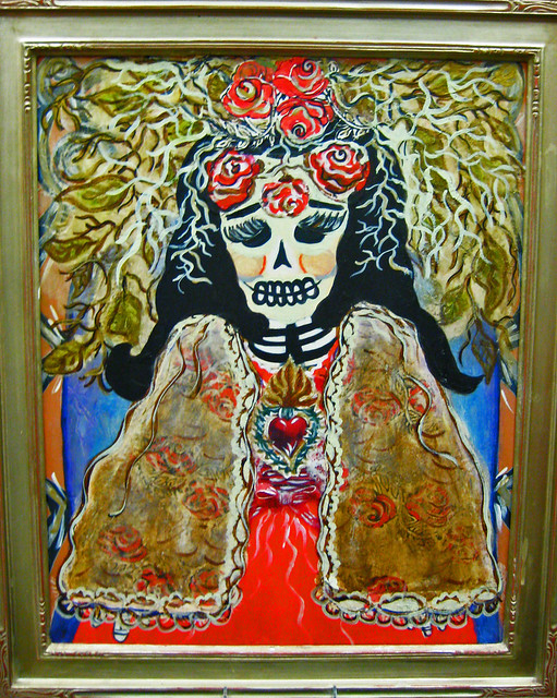 Mixed media image of calavera under a tree with roses leaves and thorns