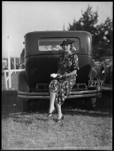Woman sitting on bumper bar of a car at Warwick Farm racecourse