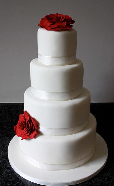 Simple ivory wedding cake with red rose detail