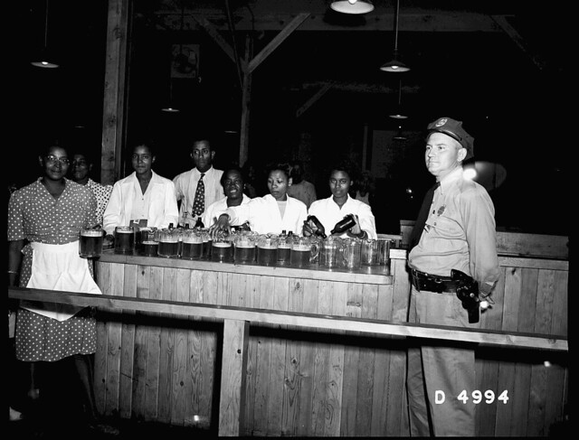 WAITRESSES PREPARING SERVING PITCHERS - SECURITY GUARD STANDING CLOSE BY