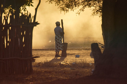 Mozambiquan woman pounds maize for the evening meal