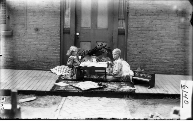 Small boy and girl at 'tea party' 1904
