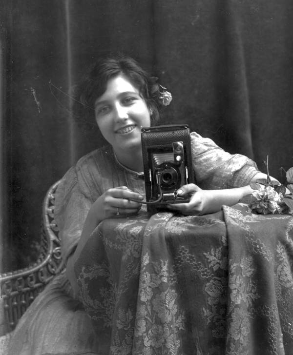 Young smiling woman, holding a camera
