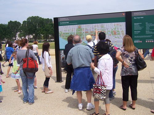 People looking at the new National Mall wayfinding signage at the Smithsonian Metro station
