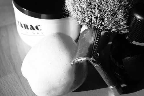 Foto in bianco e nero con set da barba, composta da pennello, ciotola, crema dopobarba