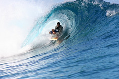 Surfing in the tube at Teahupoo, Tahiti.