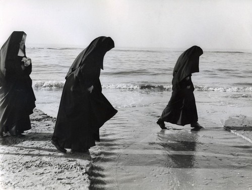 Pootjebadende nonnen op het strand / wading nuns