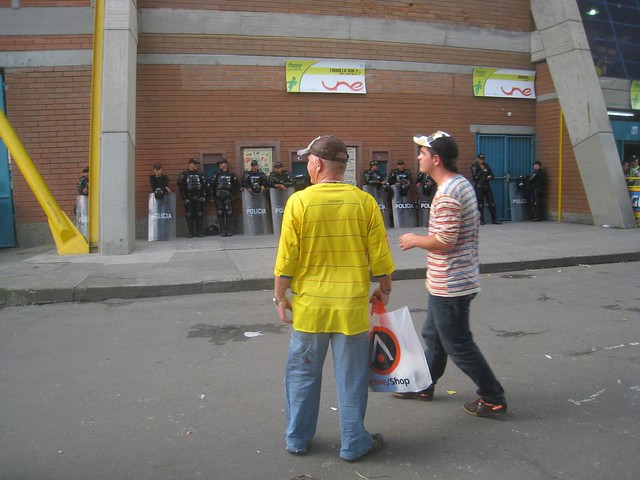 Sirleys dad and brother walk past the riot police (aka Robocops)