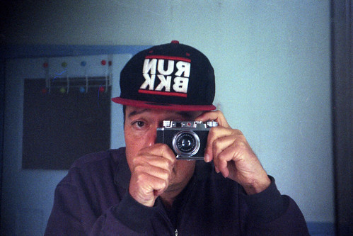 reflected self-portrait with Halina 35X camera and RUN BKK baseball cap by pho-Tony