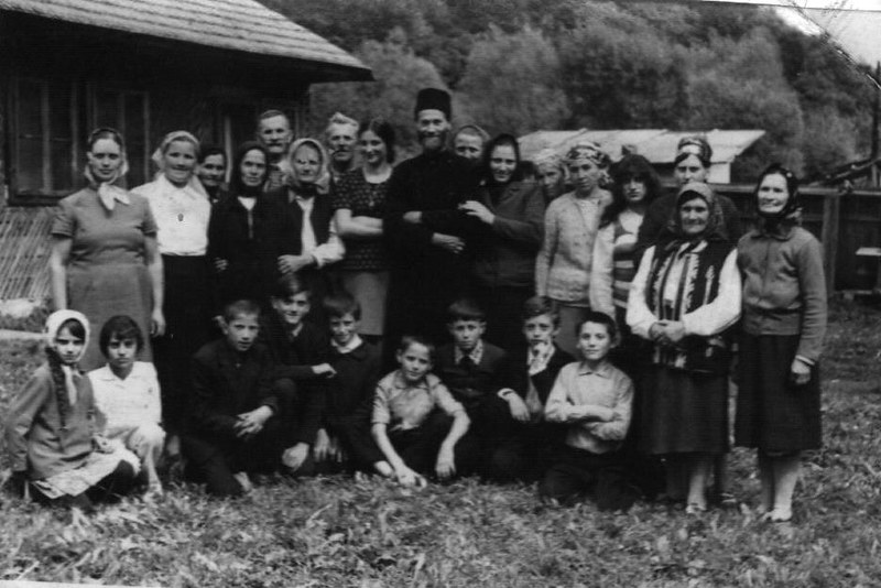 Отац Јустин у селу Петру Вода окружен породицом и верницима (~1970)
