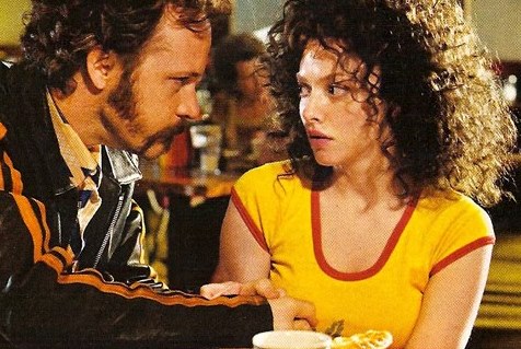A dude with  a gross mustache leans over Amanda Seyfried in Lovelace
