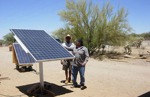 Community Coordinator Samuel Fayuant, right, explains the workings of solar panels to an engineering student from University of Massachusetts-Lowell.  The panels at Squash Burn Well in the Pisinemo District of Tohono O’odham Nation, Ariz., power the well's submersible pump.  Photo by Teresa Newberry