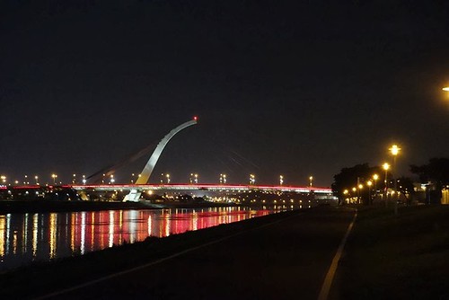 從河濱公園單車道望向夜間的大直橋，沿路照明足夠，往來運動的民眾頗多，十分安全。