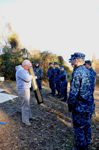 NRCS soil scientist Dean Cowherd explains a soil horizon to the midshipmen before they begin to dig. NRCS photo.