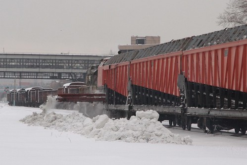 A conveyor belt at the far end of the hopper wagons discharges collected snow