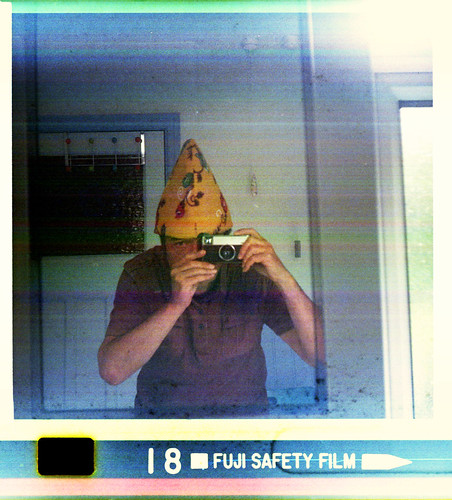 reflected self-portrait with Kodak Instamatic 233 camera and narrow yellow hat by pho-Tony