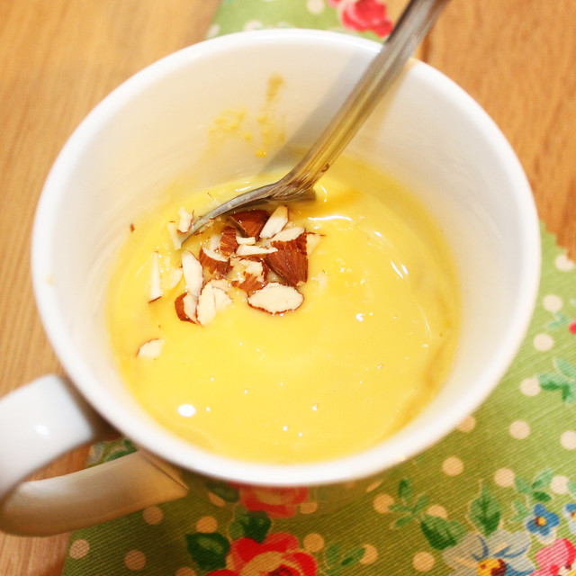 Gingerbread Mug Cake topped with custard and almonds