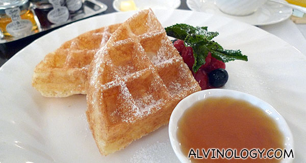 Belgian waffle served with honey and berries 