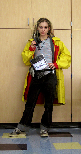 A girl dresses up as Harriet the Spy in a yellow raincoat.