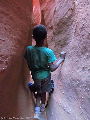 A child walking through Spooky Slot, Dry Fork Slots, Grand Staircase-Escalante National Monument, Utah