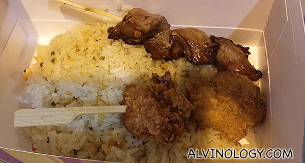 A box of rice with two skewers 