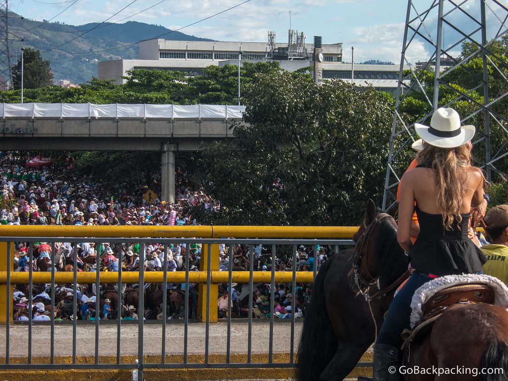 A female rider stops to watch the parade of horses go by the Poblado metro station below