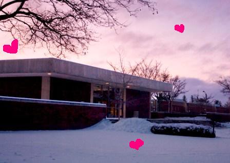 Tiny pink hearts float in front of the snowy UGL at sunset.