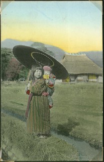 Japanese girl with an umbrella and a child in a baby carrier