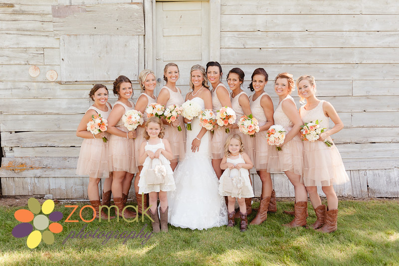 Sweet shot of the bridesmaids, bride and flower girls near a barn on the farm property.