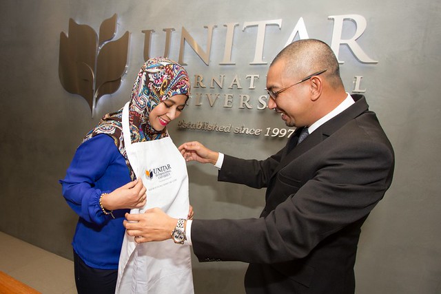 Syura menerima Apron ditempah khas untuknya sebagai Duta Jenama UNITAR International University