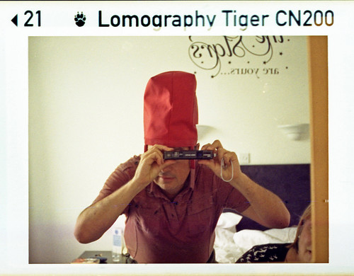 reflected self-portrait with Agfamatic 5008 makro pocket camera and makeshift red hat by pho-Tony