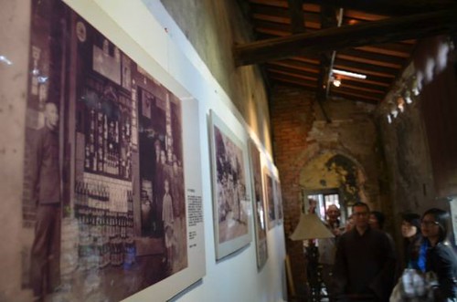 牆上的照片展示120年前「源古本舖」的雜貨店樣貌。（黃淑玲攝）