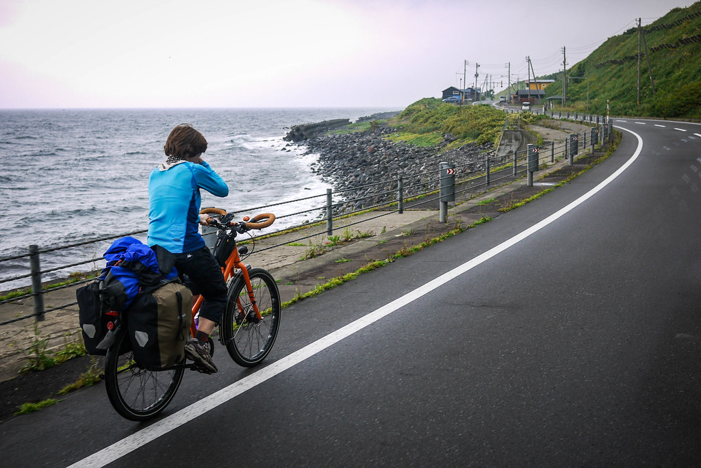 Cycling past a rugged coast on Rishiri Island, Japan